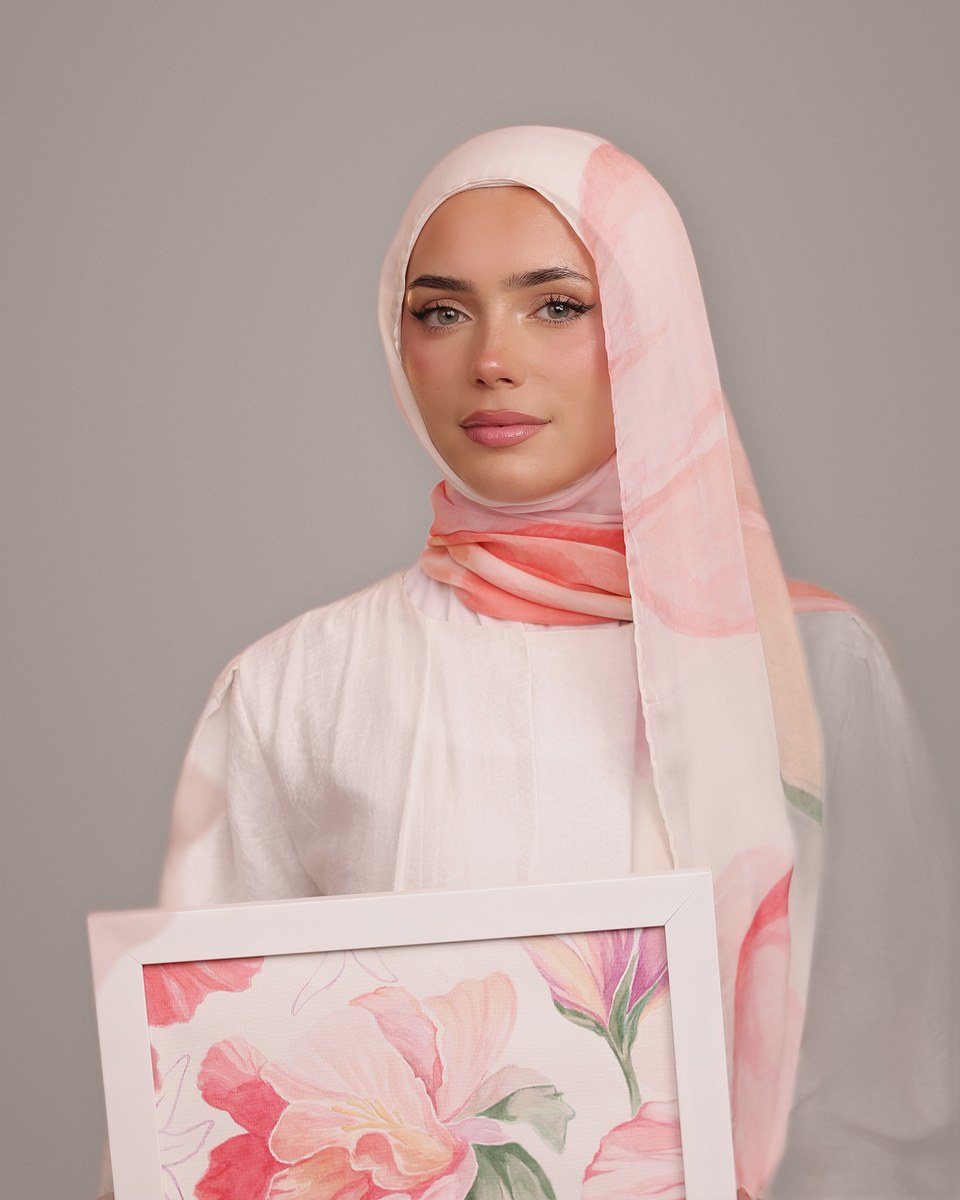 The model wearing the Blush Hibiscus silk scarf, holding the original painting