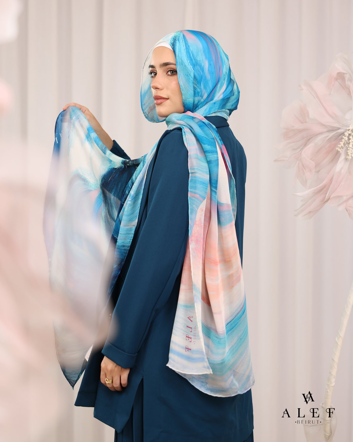 The Aqua Tide silk scarf, with a teal jacket, from behind