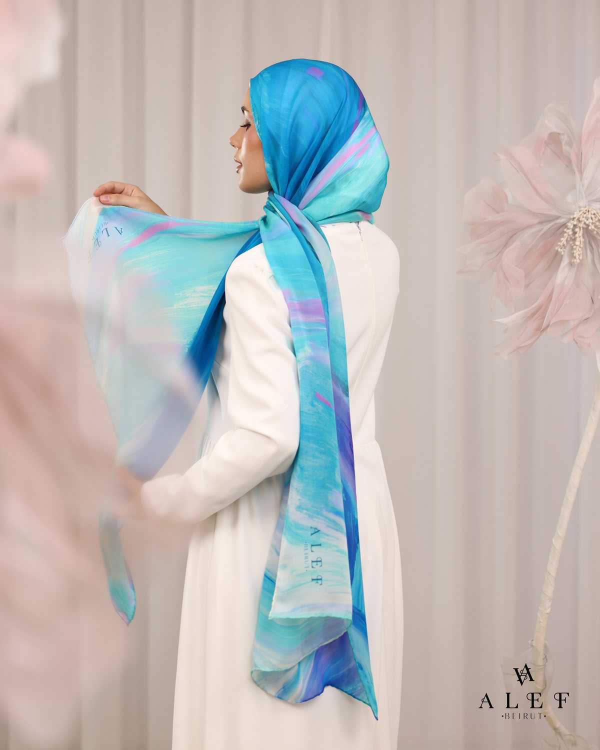 The Turquoise Lagoon silk scarf, held open, from behind